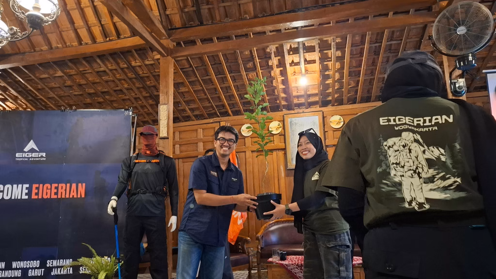 Community & Partnership EIGER Adventure, Azmi Luqman Zulkifli, menyerahkan bibit pohon kepada perwakilan komunitas.