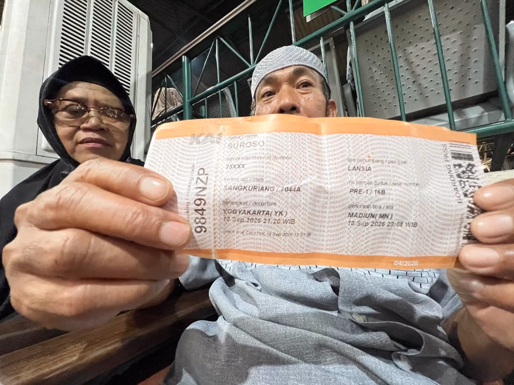 Suroso dan Ratnani menunjukkan tiket KA Sangkuriang yang akan membawa mereka pulang ke Madiun.